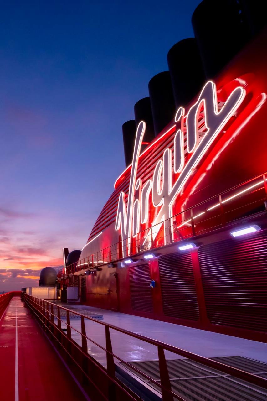 Virgin Voyages Resilient Lady — neon deck at sunset